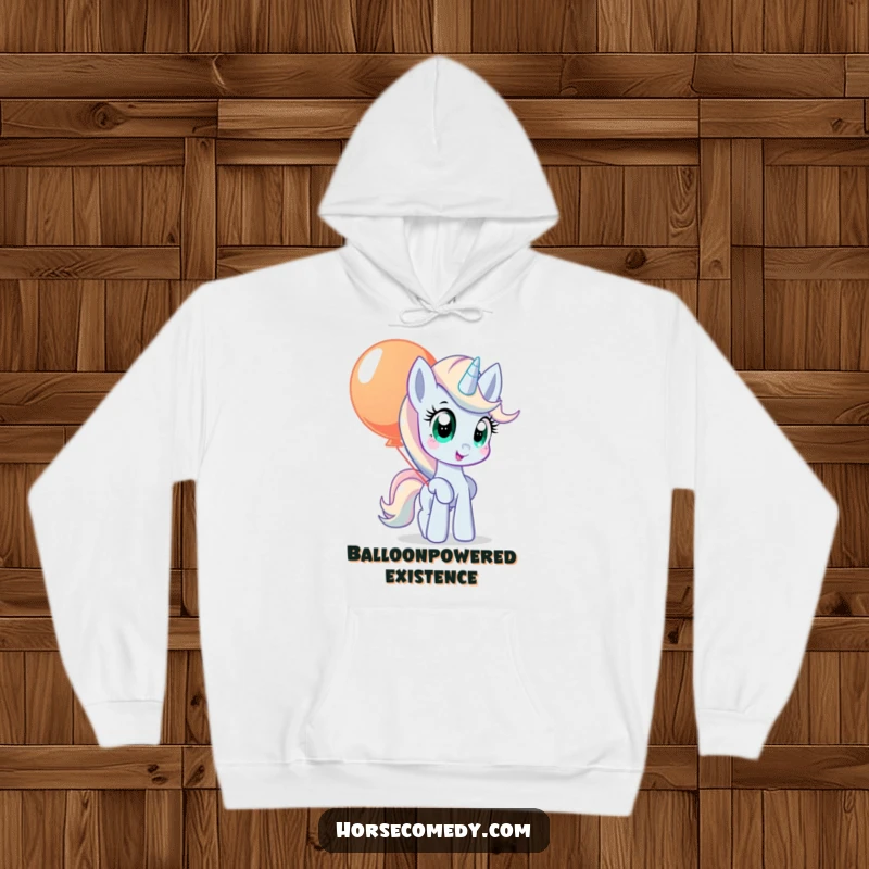 Funny pony hoodie showing a pony with wide, curious eyes, balancing a large, colorful balloon.