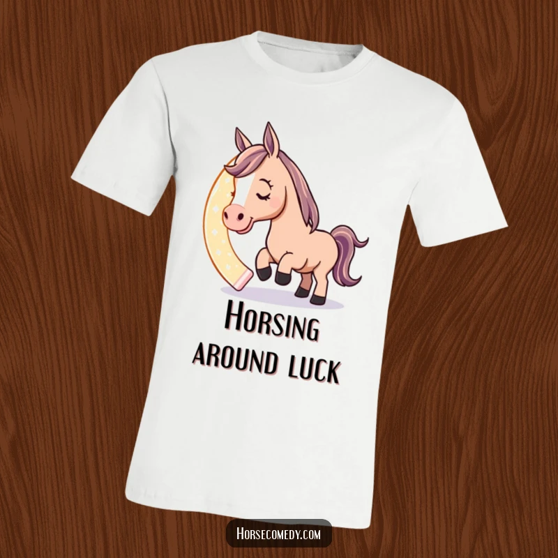 Funny t-shirt depicting a horse character playfully nudging a giant, glowing horseshoe with its nose, symbolizing luck and humorous charm.